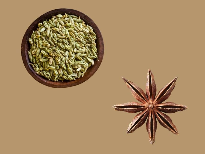 Fennel seeds in a wooden bowl and dried star anise on a brown background – natural ingredients used in breast milk increasing powder for lactating mothers.