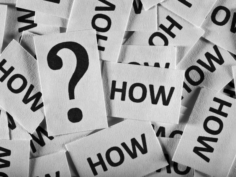 Question mark and word ‘How’ written on paper cards – representing how to use breast milk increasing powder for better lactation support.